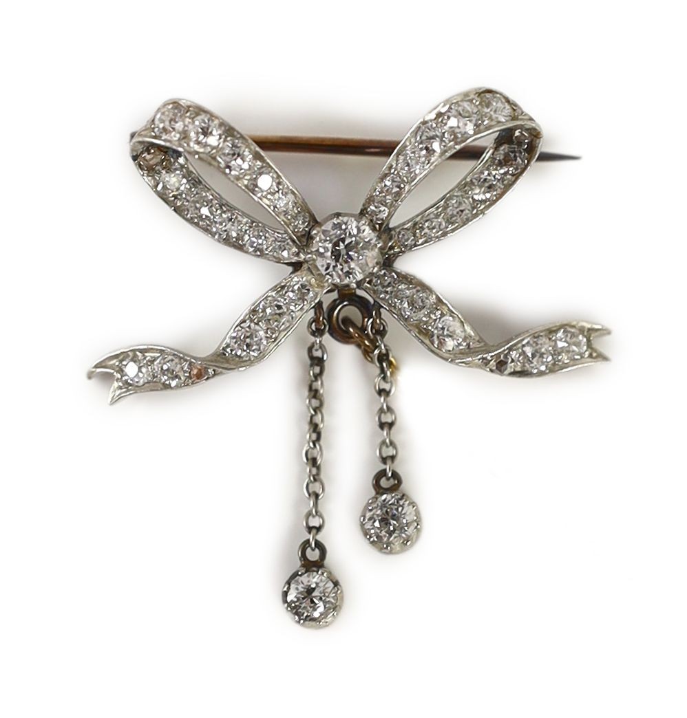 A Victorian gold, silver and diamond cluster set ribbon bow brooch, with two diamond set graduated drops